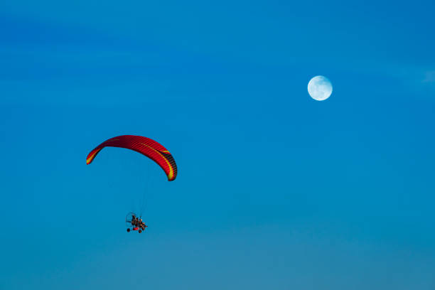 istock Flying with paramotor in the blue sky - Man riding paramotor in the blue sky background. 1775761752