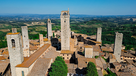 Aerial view of the town of San Gimignano in Tuscany Italy with summer weather, Aerial view of the town of San Gimignano in Tuscany, one of the most beautiful medieval towns in the Tuscany region of Italy

San Gimignano is a small walled medieval hill town in the province of Siena, Tuscany, north-central Italy. Known as the Town of Fine Towers, San Gimignano is famous for its medieval architecture, unique in the preservation of about a dozen of its tower houses.

The Palazzo Comunale, the Collegiate Church and Church of Sant' Agostino contain frescos, including cycles dating from the 14th and 15th centuries. The 