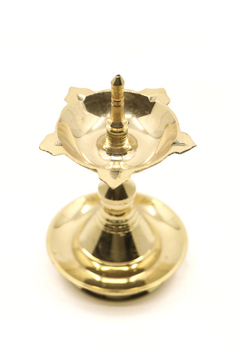 a vintage, brass oil lamp of unique traditional design used for temple celebration and festival rituals, also called as diya, vilakku or samai isolated
