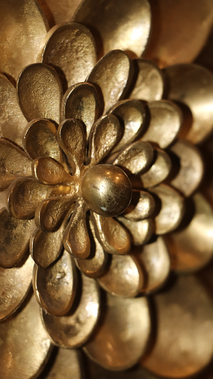 closeup of detailed golden sculpture in flower pattern carved in the handcrafted artistic interior of an ancient palace