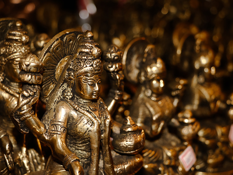 closeup shot of a goddess laxmi devi idol carved in bronze in a religious antique souvenir shop