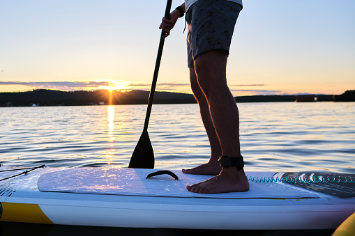 Close-up of male legs on a paddle board.