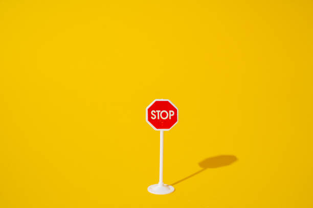 istock stop sign on yellow background, minimal road sign concept. 1775787694