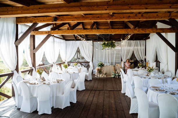 istock Serving a festive table, placing plates on the table, a Banquet table with a white tablecloth, preparing the dining table for the holiday, Cutlery is arranged according to etiquette. flowers on the table. 1775788255