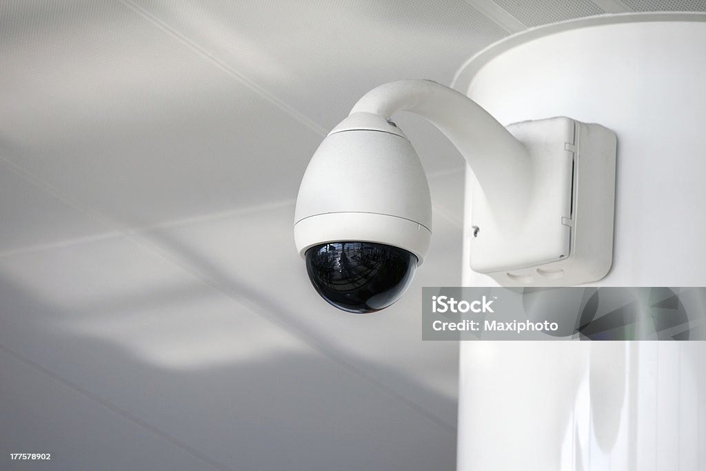 Security camera at airport Big brother is watching you: details of surveillance and security camera used for safety protection and  crime control. White interior and background with copy space. Alertness Stock Photo