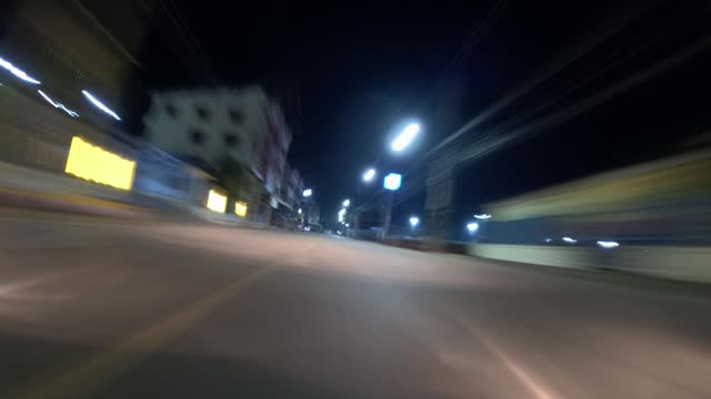 Time lapse, low view in front of the car, tilted and long exposure blurring the light.
