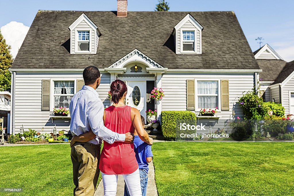 Szczęśliwa młoda Rodzina podziwiając domu - Zbiór zdjęć royalty-free (Dom - Budowla mieszkaniowa)