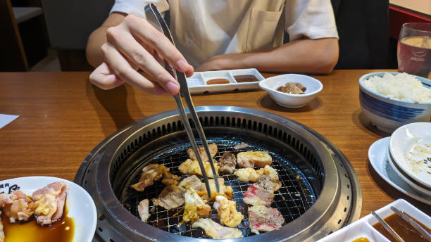 istock man grilling meat or yakiniku at restaurant. 1775837273