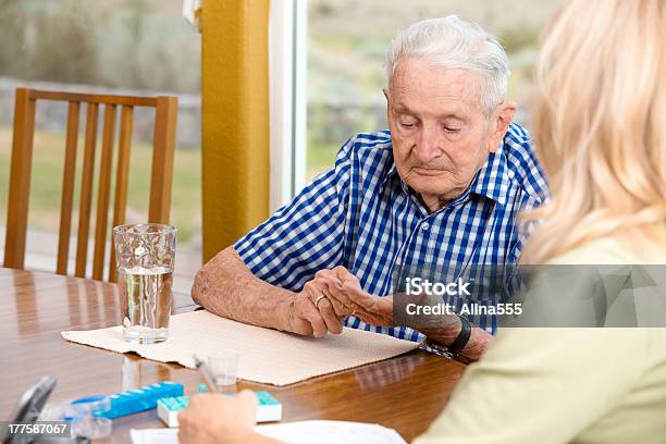 Trabajador Social Que Notas Senior Hombre Tomando Su Medicamento Foto de stock y más banco de imágenes de Tercera edad