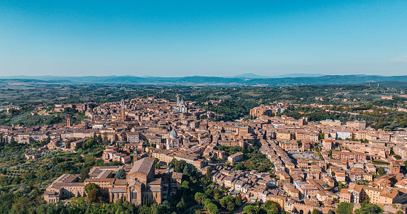 Aerial View of Siena, Aerial view of Piazza del Campo, Aerial view of Siena Cathedral in Italy-Tuscany Europe, Siena City View, Siena Cathedral

Siena is a city in Tuscany, Italy. It is the capital of the province of Siena. Siena is the 12th largest city in the region by number of inhabitants, with a population of 53,062 as of 2022.

Piazza del Campo is the main public space of the historic center of Siena, a city in Tuscany, Italy, and the campo regarded as one of Europe's greatest medieval squares. It is renowned worldwide for its beauty and architectural integrity.

The twice-a-year horse-race, Palio di Siena, is held around the edges of the piazza. The piazza is also the finish location of the annual road cycling race Strade Bianche.

Siena Cathedral (Italian: Duomo di Siena) is a medieval church in Siena, Italy, dedicated from its earliest days as a Roman Catholic Marian church, and now dedicated to the Assumption of Mary.

The Torre del Mangia is a tower in Siena, in the Tuscany region of Italy. Built in 1338-1348, it is located in the Piazza del Campo, Siena's main square, next to the Palazzo Pubblico (Town Hall). When built it was one of the tallest secular towers in medieval Italy.