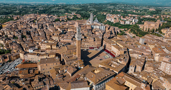 Aerial View of Siena, Aerial view of Piazza del Campo, Aerial view of Siena Cathedral in Italy-Tuscany Europe, Siena City View, Siena Cathedral\n\nSiena is a city in Tuscany, Italy. It is the capital of the province of Siena. Siena is the 12th largest city in the region by number of inhabitants, with a population of 53,062 as of 2022.\n\nPiazza del Campo is the main public space of the historic center of Siena, a city in Tuscany, Italy, and the campo regarded as one of Europe's greatest medieval squares. It is renowned worldwide for its beauty and architectural integrity.\n\nThe twice-a-year horse-race, Palio di Siena, is held around the edges of the piazza. The piazza is also the finish location of the annual road cycling race Strade Bianche.\n\nSiena Cathedral (Italian: Duomo di Siena) is a medieval church in Siena, Italy, dedicated from its earliest days as a Roman Catholic Marian church, and now dedicated to the Assumption of Mary.\n\nThe Torre del Mangia is a tower in Siena, in the Tuscany region of Italy. Built in 1338-1348, it is located in the Piazza del Campo, Siena's main square, next to the Palazzo Pubblico (Town Hall). When built it was one of the tallest secular towers in medieval Italy.