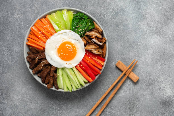 istock Korean dish Bibimbap with rice, beef, vegetables, mushrooms and fried egg. Gray concrete background. Top view, flat lay, copy space. 1775905294