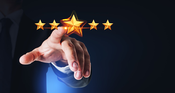 Hand of unrecognizable businessman giving five star rank over dark blue background. Concept of giving service feedback and rating. Mock up