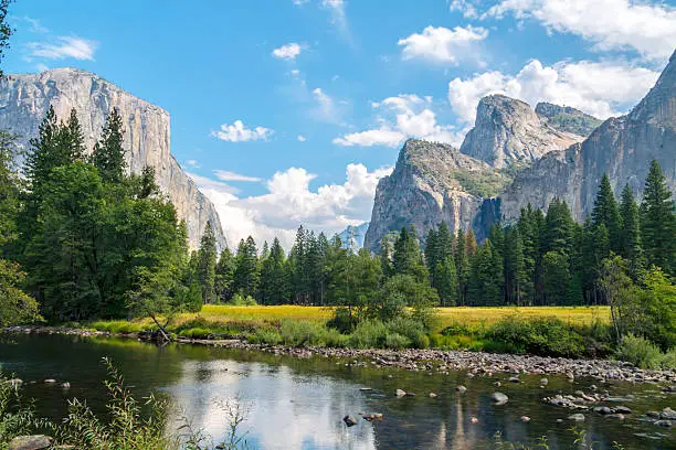Yosemite National Park with partial view of El Capitan on the left and Merced River in foreground