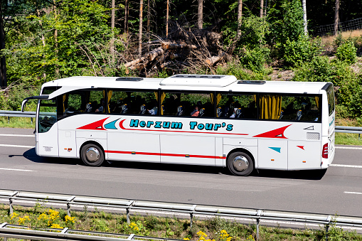 Wiehl, Germany - June 26, 2020: Herzum Tour’s Mercedes-Benz Tourismo intercity bus on motorway
