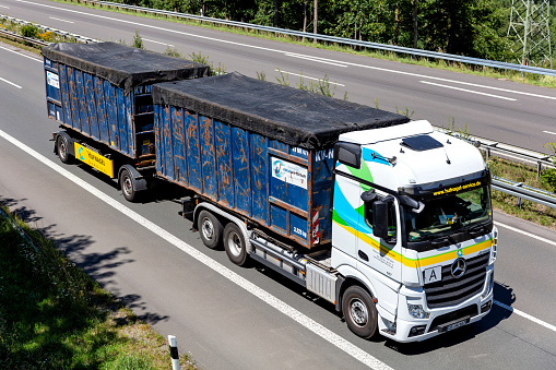 Wiehl, Germany - June 26, 2020: Hufnagel Mercedes-Benz Actros roll-off container truck on motorway