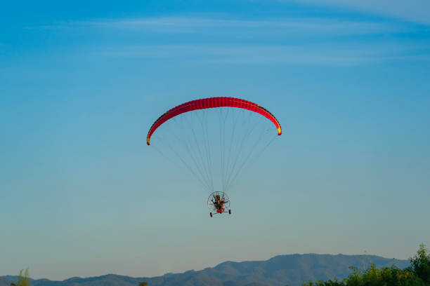 istock Flying with paramotor in the blue sky - Man riding paramotor in the blue sky background. 1775944053