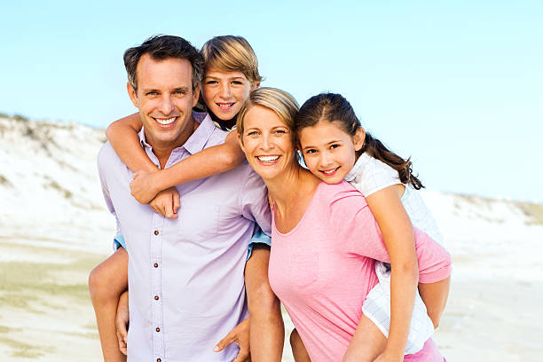 istock Parents Piggybacking Children At Beach 177594514