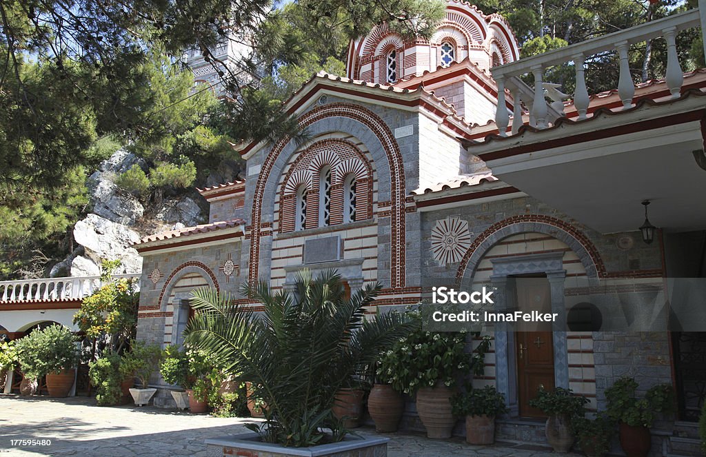 Beautiful monastery in old garden (Crete, Greece) Beautiful garden patio and flower pots in old mountain orthodox monastery(Crete, Greece) Abbey - Monastery Stock Photo