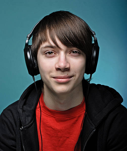 Teenager Teenager in headphones, might be listening to music or playing video game emo boy stock pictures, royalty-free photos & images
