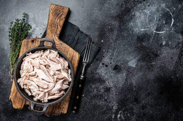 istock Sliced Pieces of chicken meat in a skillet, pulled chicken. Black background. Top view. Copy space 1775990327