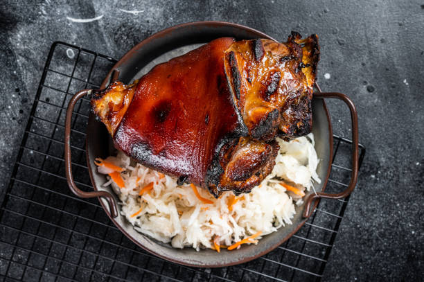 traditional german cuisine roasted pork knuckle schweinshaxe with sauerkraut. black background. top view - shank sauerkraut german cuisine pork imagens e fotografias de stock