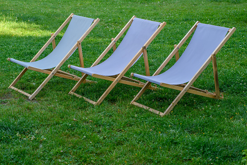 Elegant deckchairs placed neatly on the green grass isolated