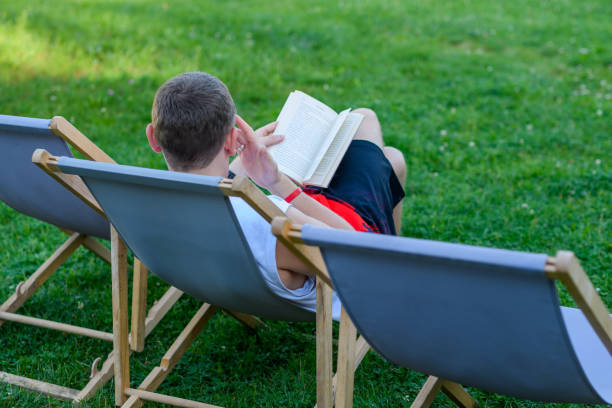 istock Free time, a man relaxes on a deck chair reading a book 1775993979