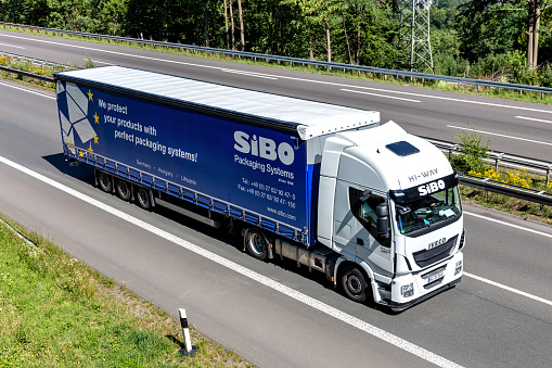 Wiehl, Germany - June 26, 2020: SiBO Iveco Stralis truck with curtainside trailer on motorway