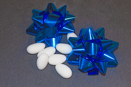 Confetti! Dolci tipici per le cerimonie con fiocchi blu, su fondo neutro
