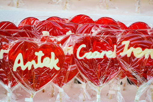 Stall with heart shaped red lollipops on sticks with polish names