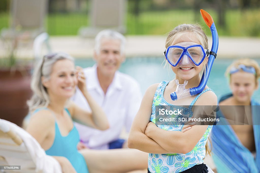 Bambina carina indossando snorkeling e nuotare con i nonni - Foto stock royalty-free di Piscina