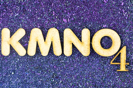 Chemical formula of potassium permanganate against potassium permanganate background.