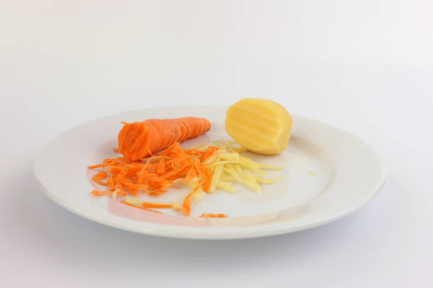 Grated carrots and potatoes on a white plate.