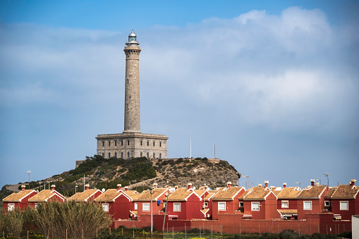 Cabo de Palos lighthouse, near Murcia, Spain, towering over a row of houses