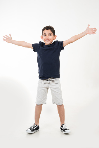 boy is on white background his arms are open and he is smiling vertical kid still