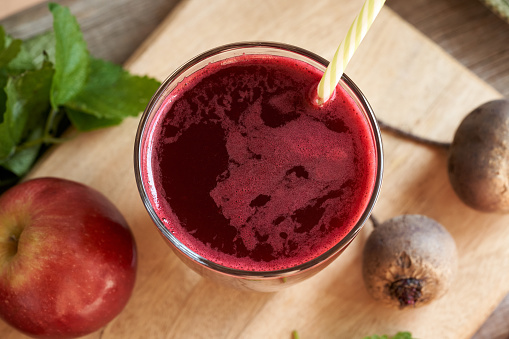 Beetroot and pomegranate smoothie on brown wooden table, detox and dieting concept