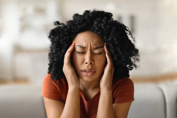 Migraine Concept. Closeup Shot Of Stressed Black Woman Touching Head With Hands Migraine Concept. Closeup Shot Of Stressed Black Woman Touching Head With Hands, Young African American Female Massaging Temples, Suffering Acute Headache While Relaxing At Home, Free Space bushy stock pictures, royalty-free photos & images