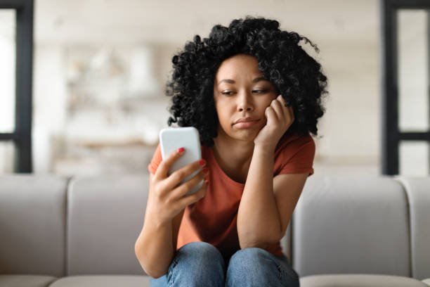 istock Bored Young Black Female Looking At Smartphone Screen At Home 1776137526