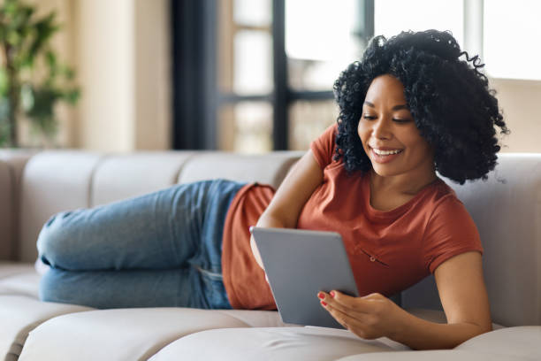 istock Great App. Black Female With Digital Tablet Lying On Couch At Home 1776137792