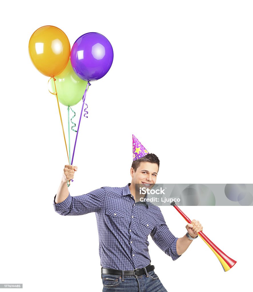 Happy male holding balloons and a horn Portrait of a happy male holding balloons and a horn isolated on white background Adult Stock Photo