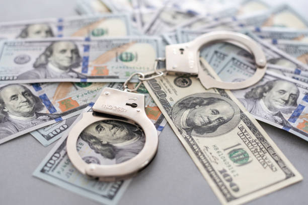 istock Handcuffs Laying on Newly Designed U.S. One Hundred Dollar Bills. 1776145709