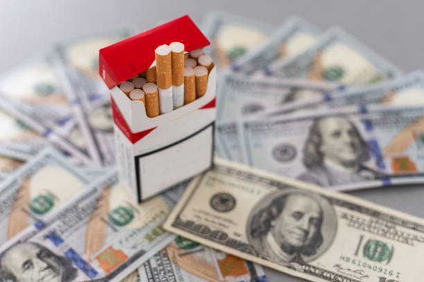 istock Concept of smoking cost. Cigaretes on a dollars background. 1776145766