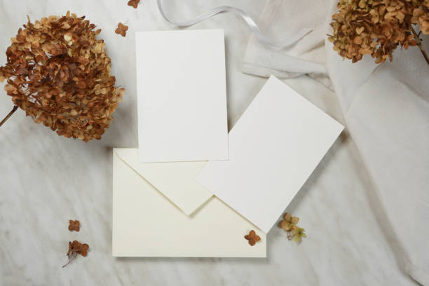 istock Blank wedding invitation card mockup with envelope and dry hydrangea flowers. Flat lay, top view. 1776173087