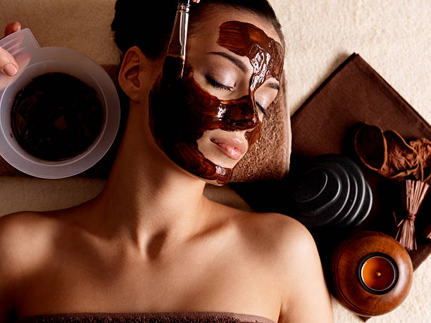 Photo of woman at a spa wearing a mud mask and relaxing stock photo