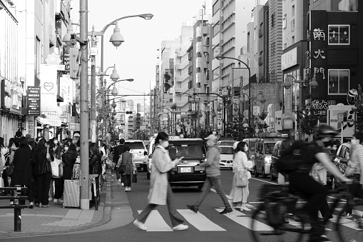 People walking on the busy Okubo Dori avenue in Shin-Okubo, a neighborhood with a South Korean vibe mixed with a little bit of Southeast Asia, also called Korea Town of Tokyo and part of Shinjuku district in Tokyo, Japan.