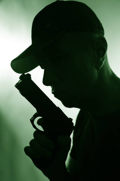 총을 든 모자를 쓴 젊은 범죄자 - hit man 뉴스 사진 이미지