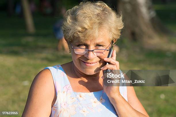 Sonriente Mujer De Edad Avanzada Con Un Teléfono Foto de stock y más banco de imágenes de Jardín privado - Jardín privado, Mujeres, Sonreír