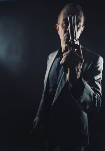 istock Spy in elegant suit with pistol gun in dark 1776220936