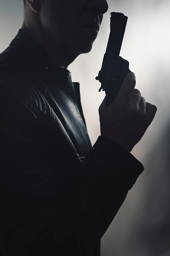 A smart gangster holding a gun.